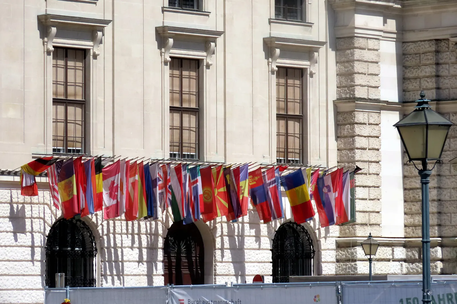 Eine Reihe von Staatenflaggen an der Fassade der Hofburg in Wien