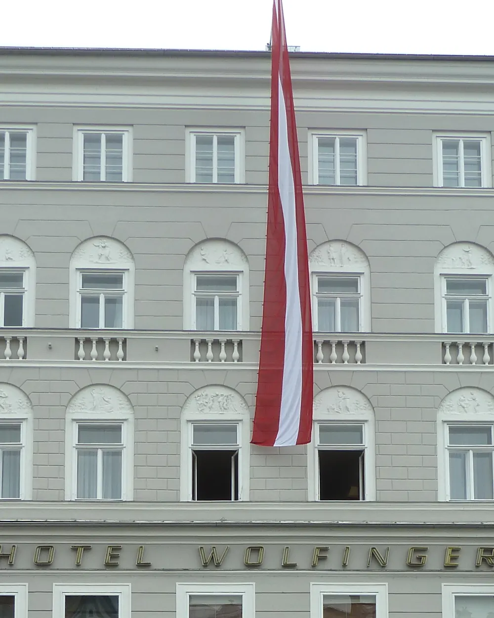 Lange rot-weiß-rote Hängefahne an einem Haus am Hauptplatz in Linz