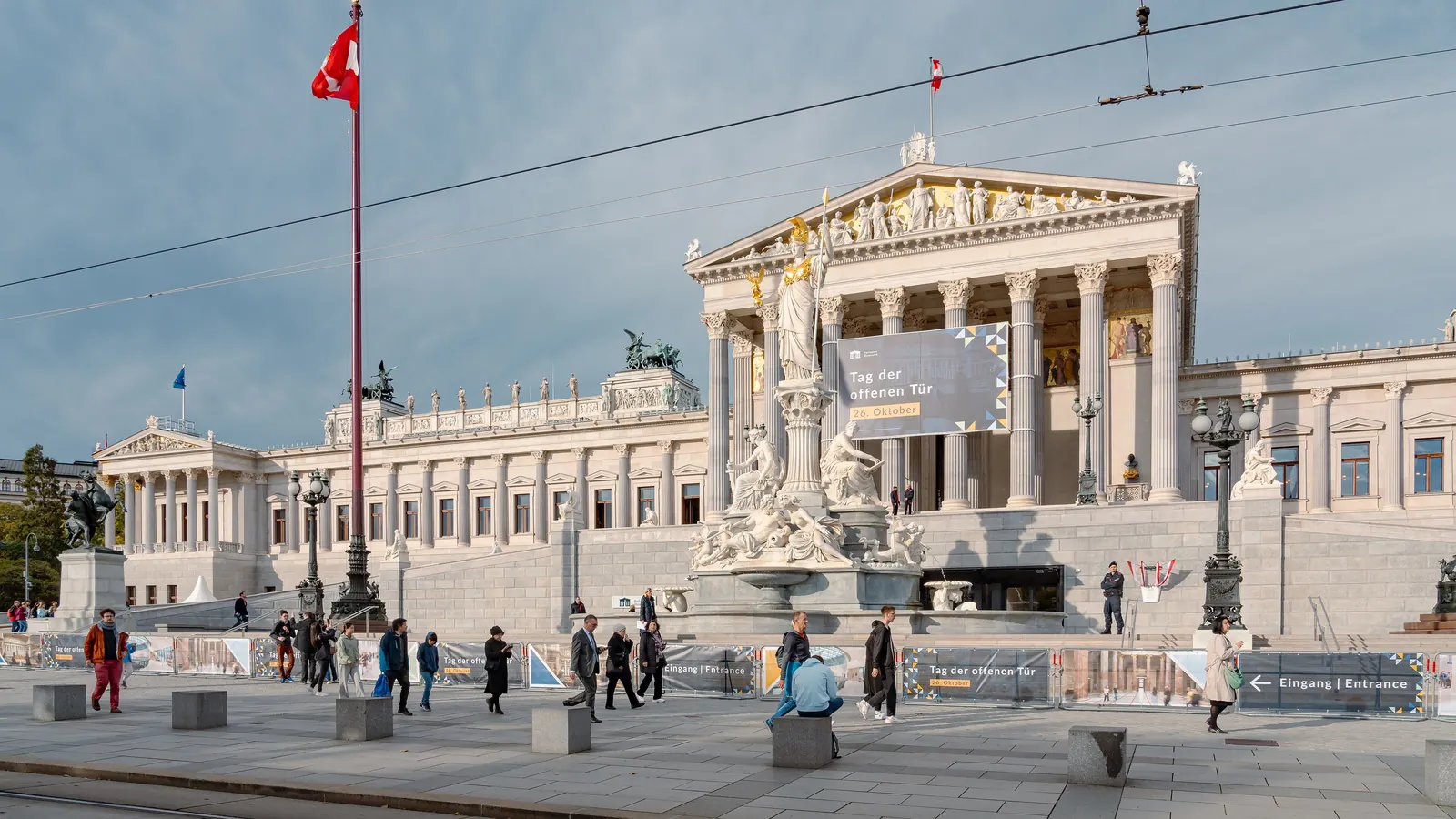 Das Parlamentsgebäude in Wien am Nationalfeiertag mit der Fahne an einem hohen Mast