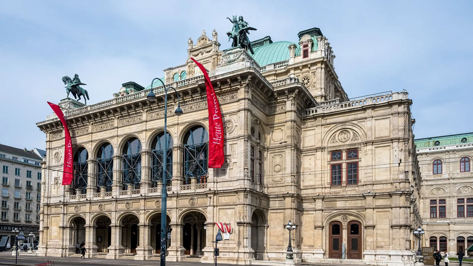 Die Wiener Staatsoper mit langen roten Fahnen an der Fassade