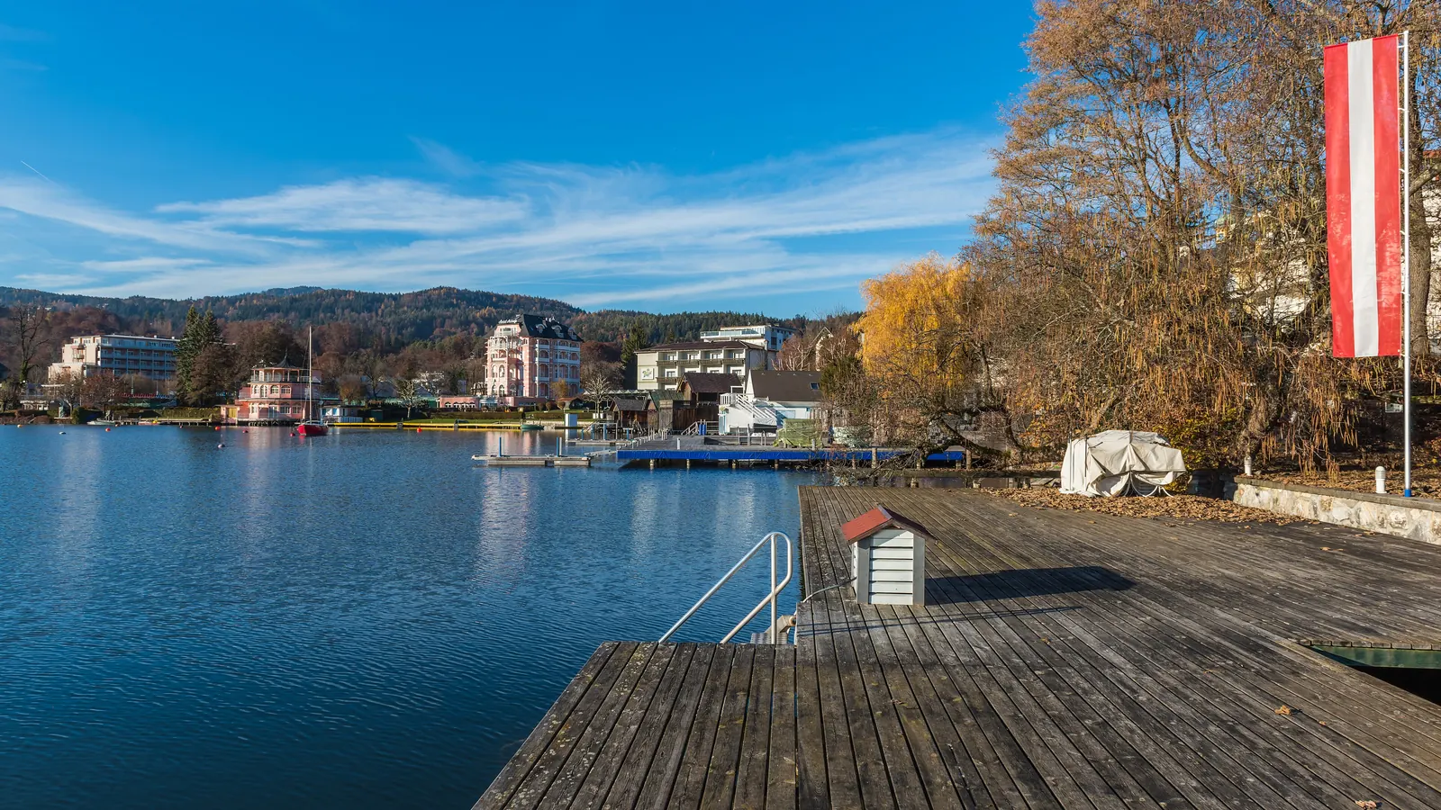 Badesteg eines Hotels in Pörtschach am Wörthersee mit einer rot-weiß-roten Fahne am Ufer