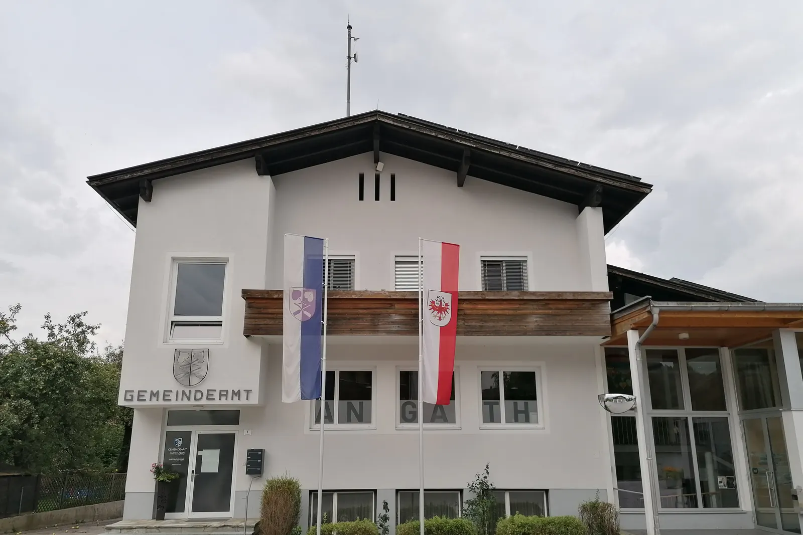 Gemeindeamt Angath mit Tiroler Fahne und Gemeindefahne am Balkon