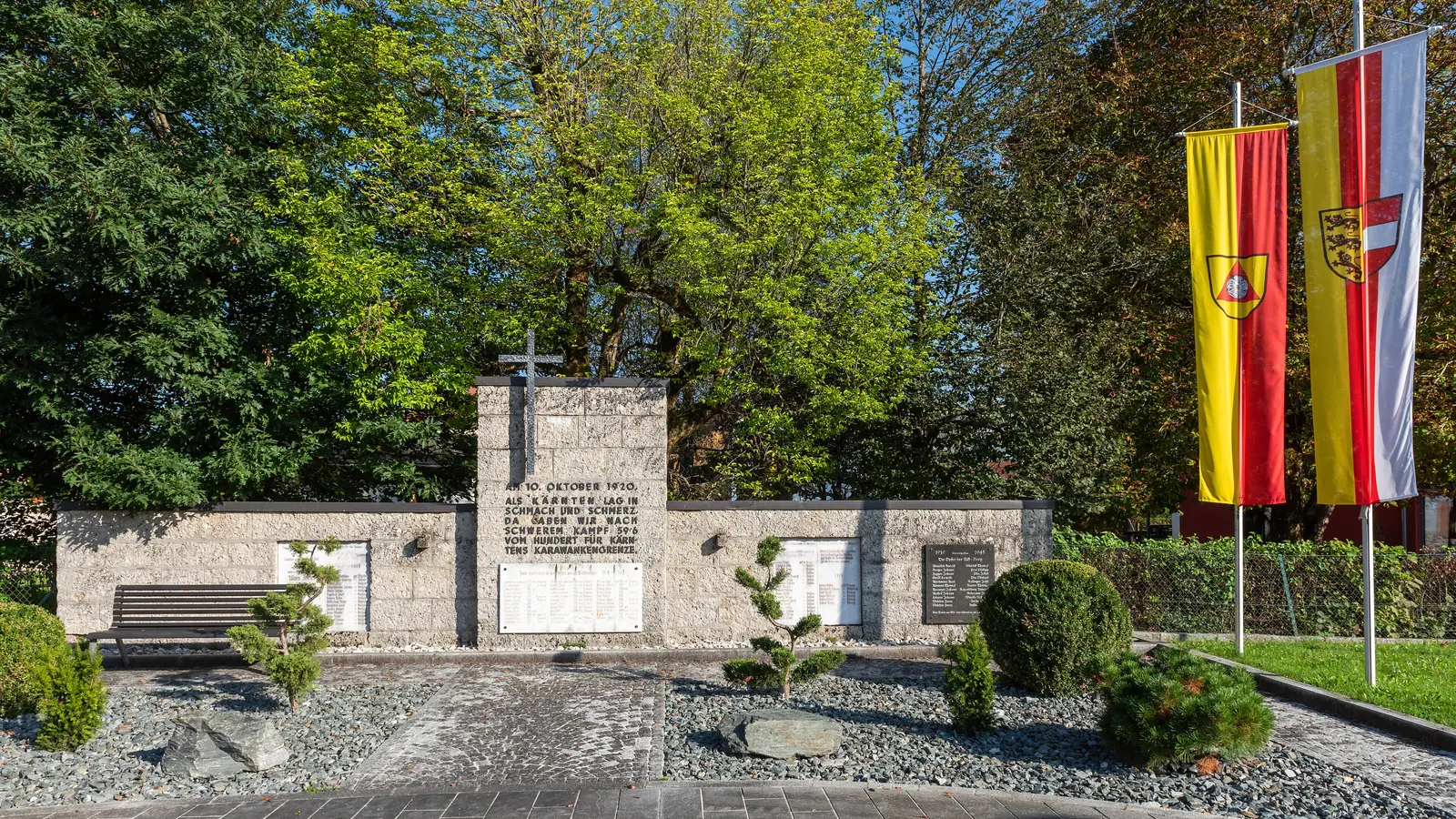 Kriegerdenkmal in Rosegg mit Kärntner Fahnen an zwei Masten