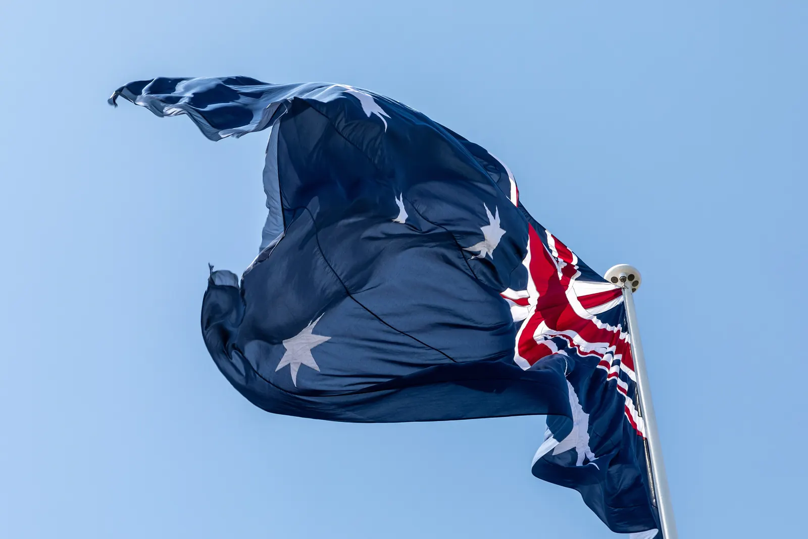 The Australian National Flag flying against a blue sky at Darling Harbour, Sydney