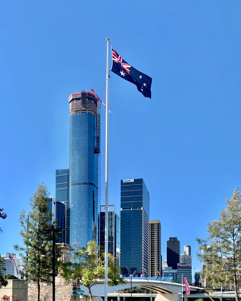The Australian National Flag on a flagpole in front of high-rise towers in Brisbane