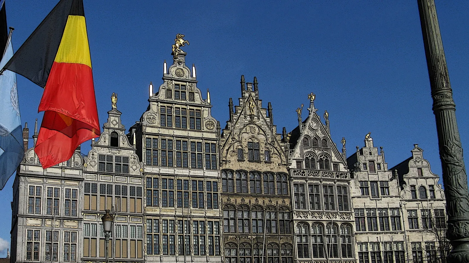 De Belgische vlag aan een mast voor de gildehuizen op de Grote Markt in Antwerpen