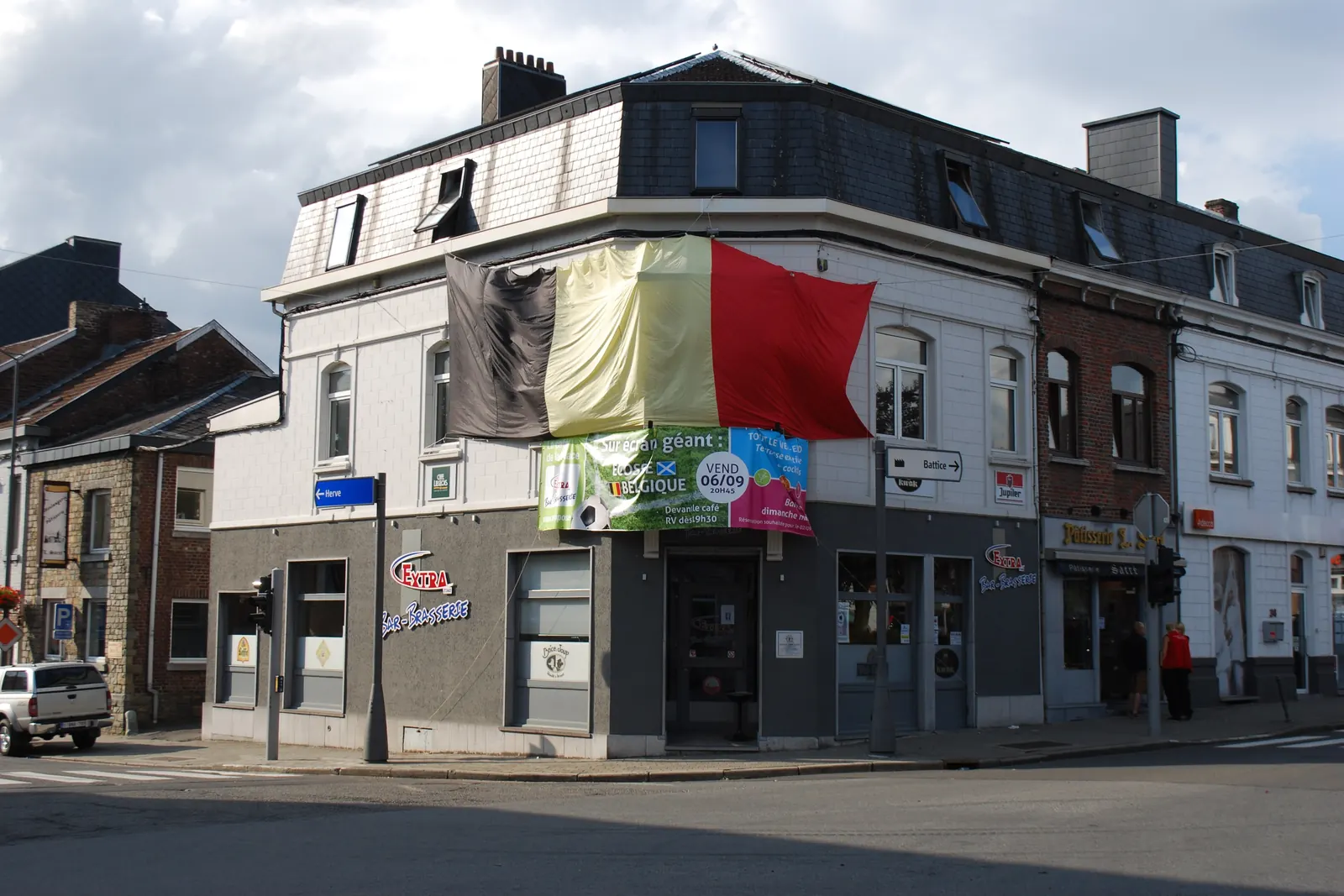 Een zeer grote Belgische vlag aan de gevel van een hoekhuis in Battice