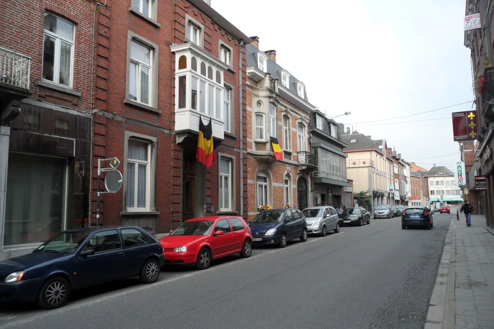Een straat in Nijvel met Belgische vlaggen aan de gevels van de huizen