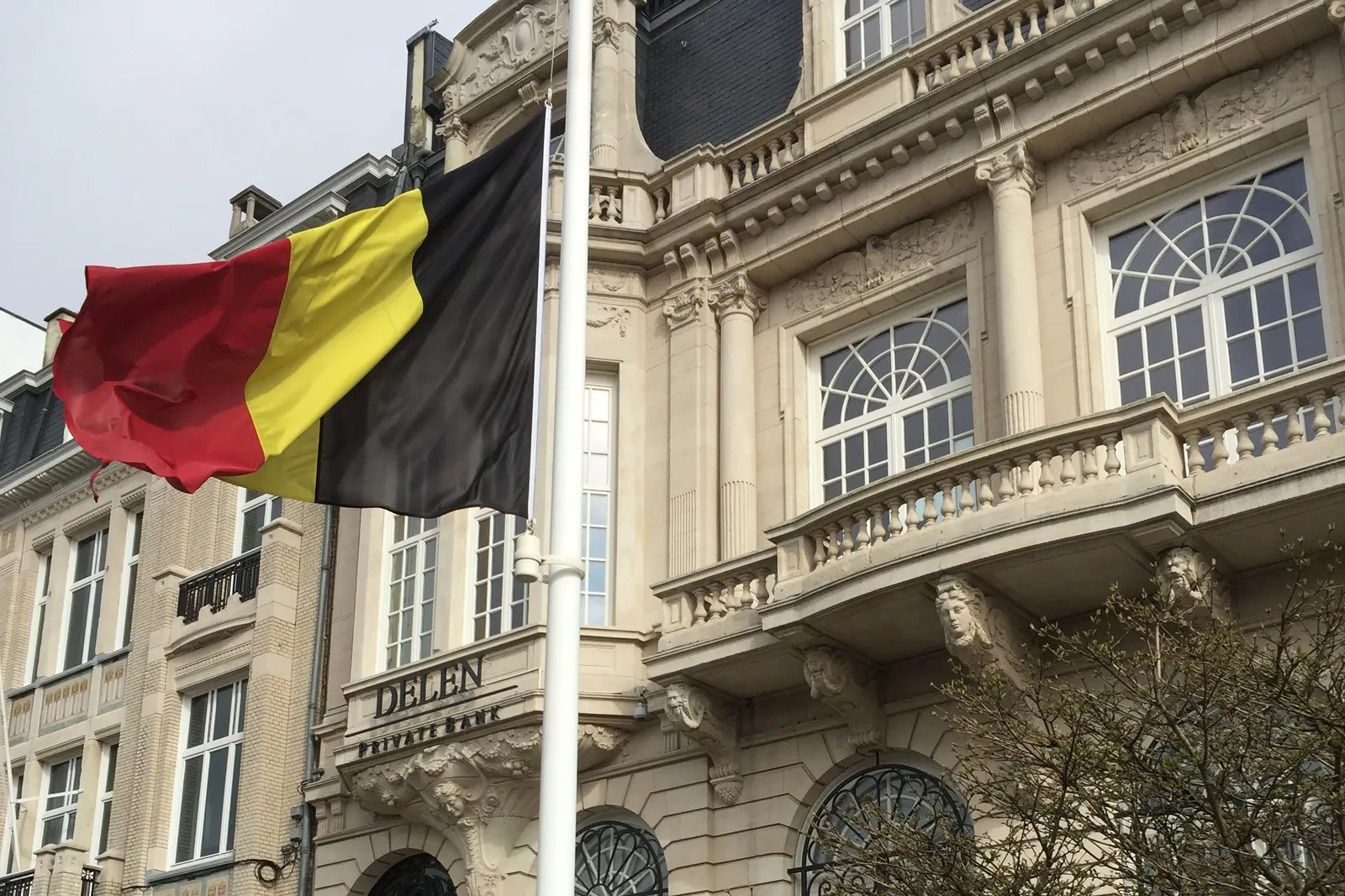 Het gebouw van een bank in Antwerpen met de Belgische vlag aan een mast voor de gevel