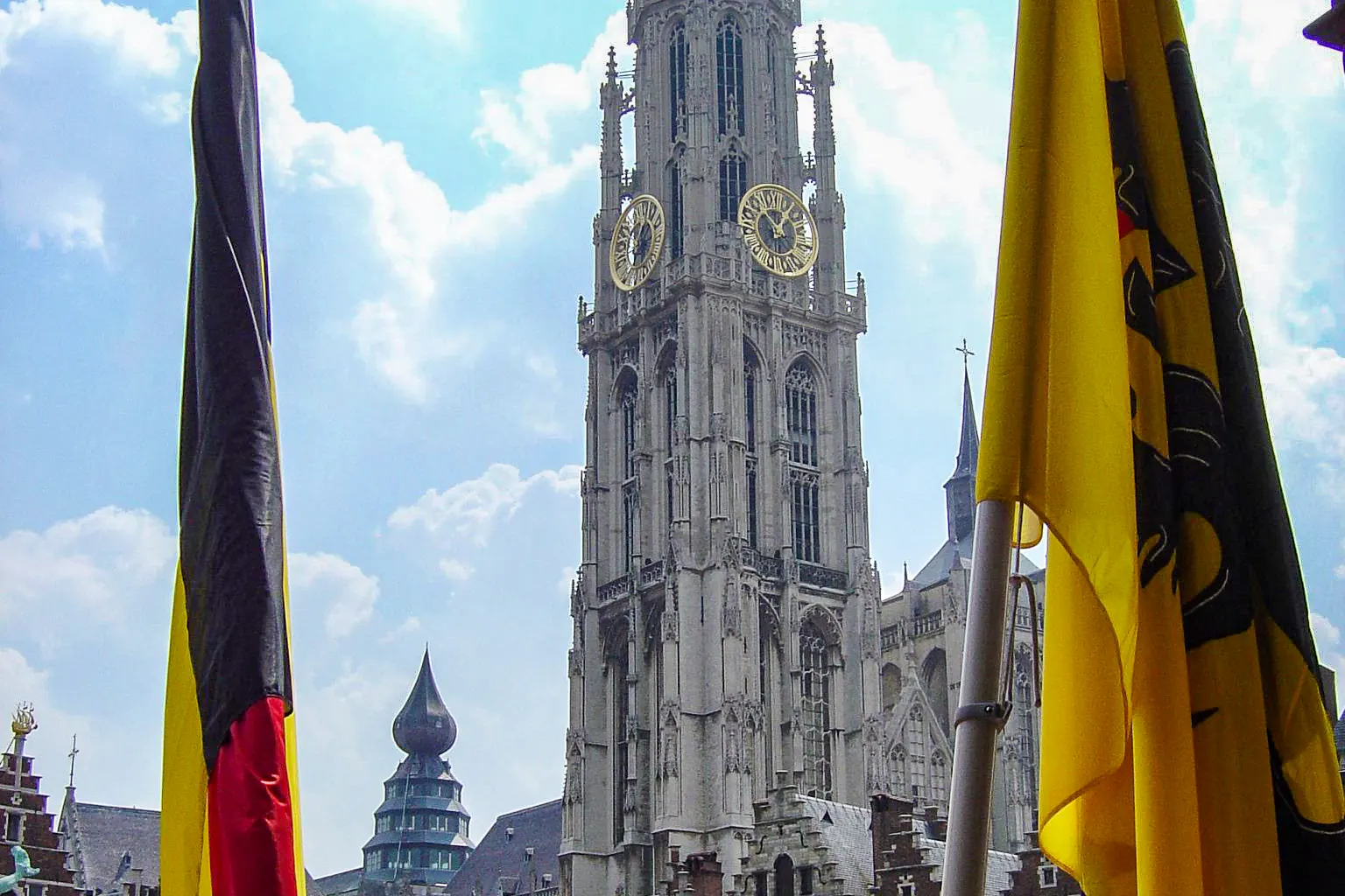 De Belgische en de Vlaamse vlag aan masten op de Grote Markt in Antwerpen, met de kathedraal tussen beide