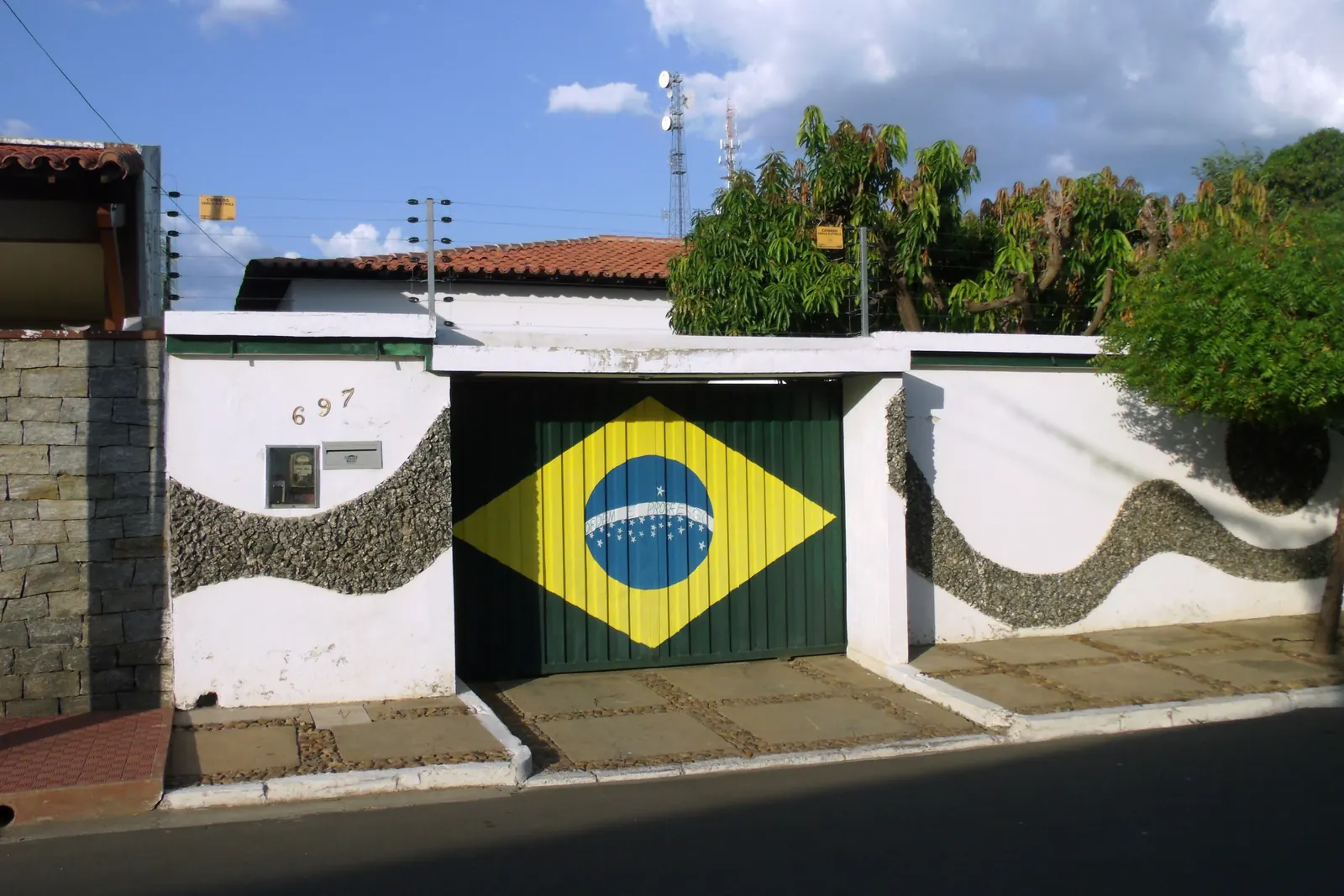 O portão de uma casa pintado com a Bandeira Nacional