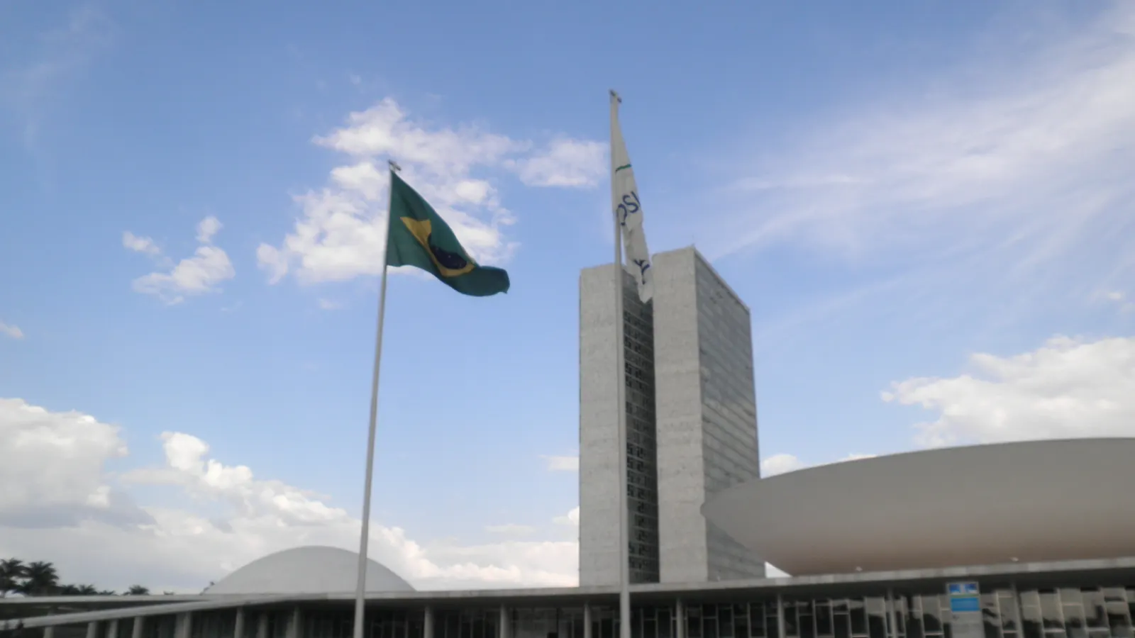 O Congresso Nacional, em Brasília, com a Bandeira Nacional em um mastro em frente