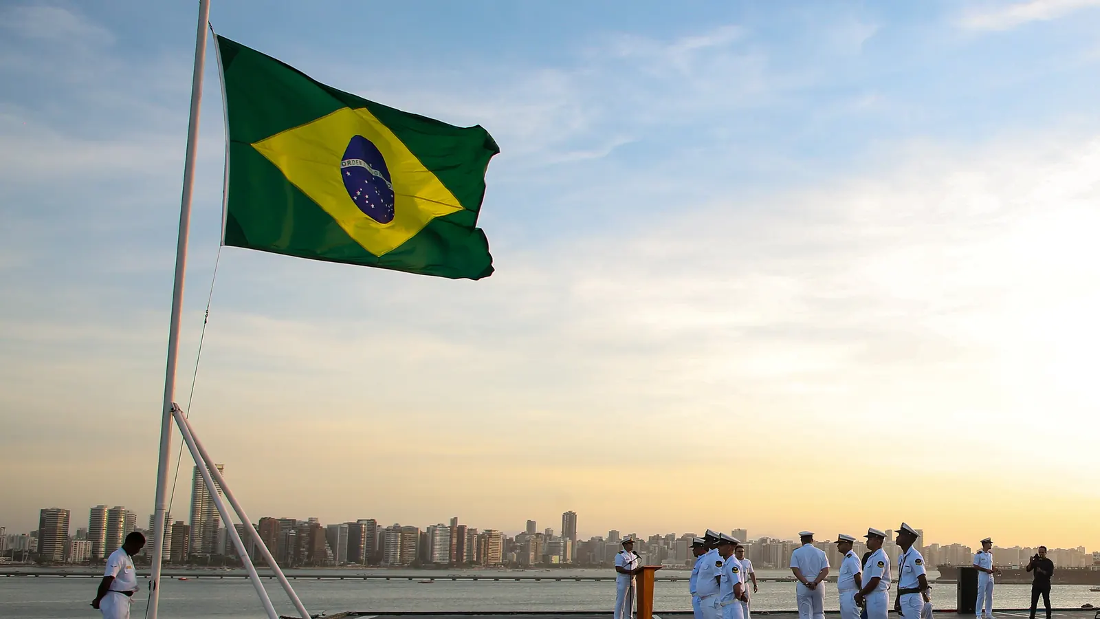 Cerimonial à Bandeira ao pôr do sol em Fortaleza, com a bandeira no mastro e a guarnição em forma