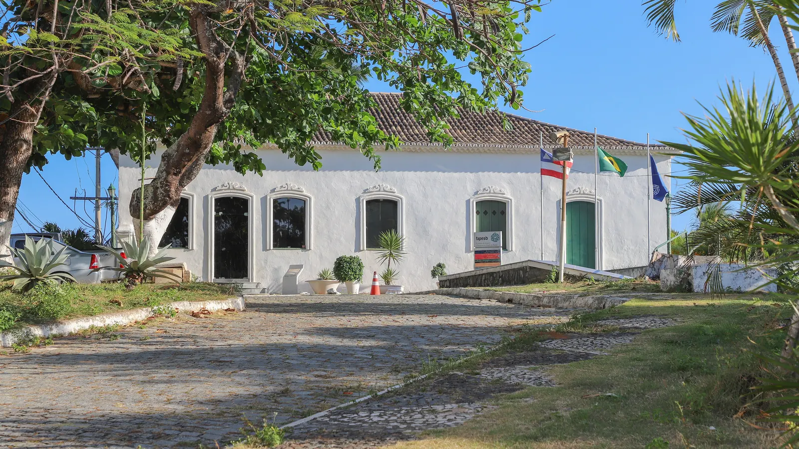 Um prédio histórico em Salvador com a Bandeira Nacional e a bandeira da Bahia em mastros