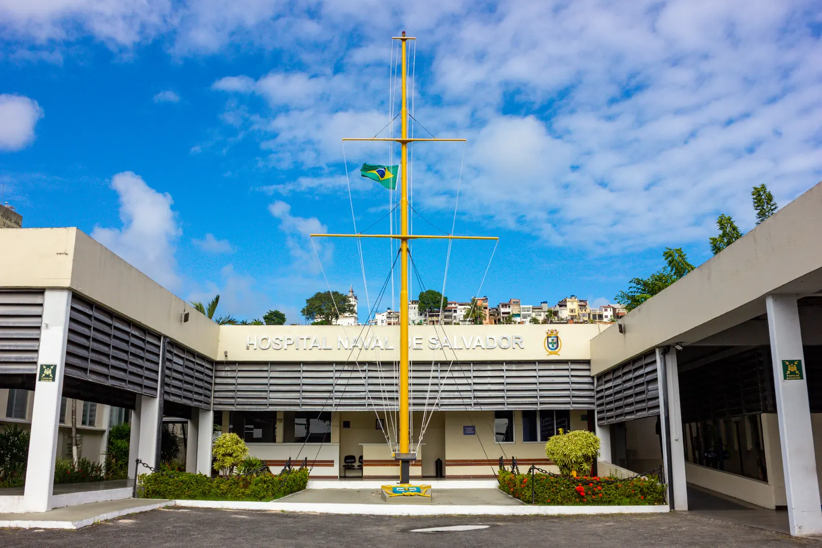Um mastro com verga e bandeiras diante do Hospital Naval de Salvador