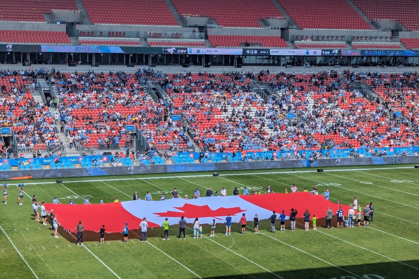 A giant flag of Canada held out on the field at BMO Field in Toronto before a football game