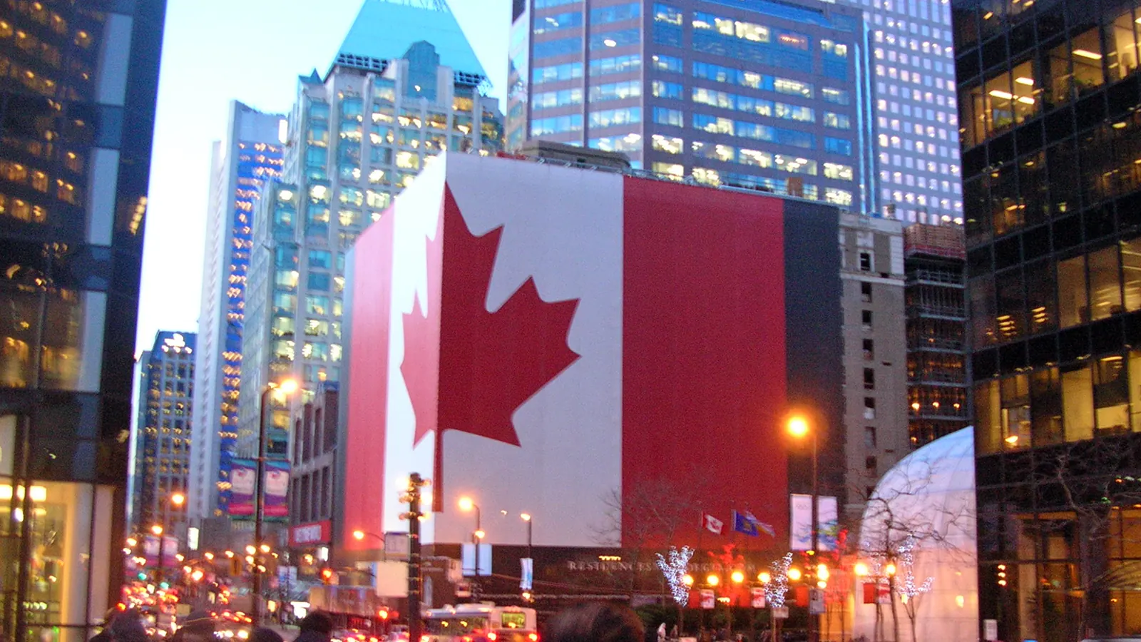 A giant flag of Canada covering the facade of a building in downtown Montréal