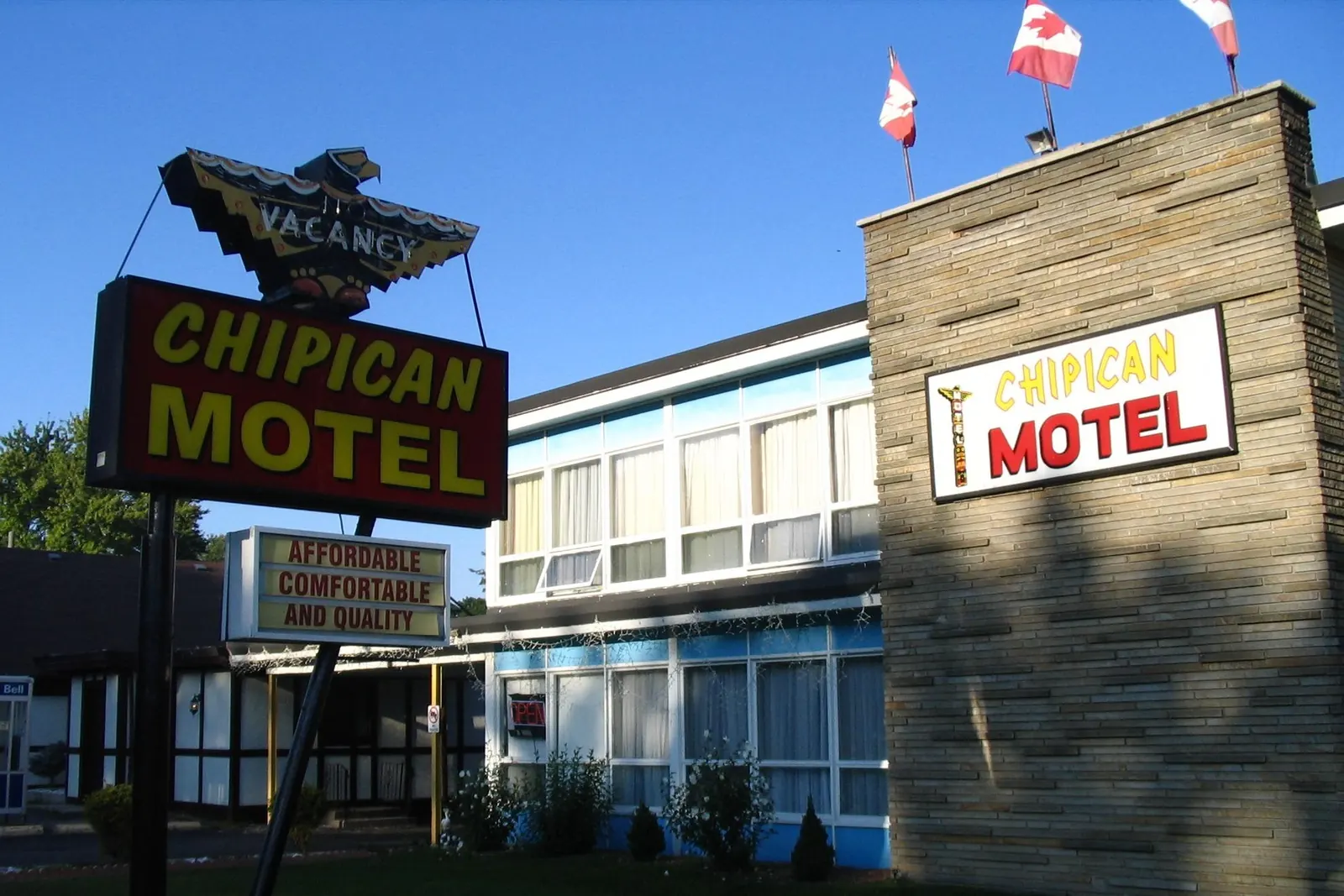 A roadside motel with Canadian flags on short poles along the roof