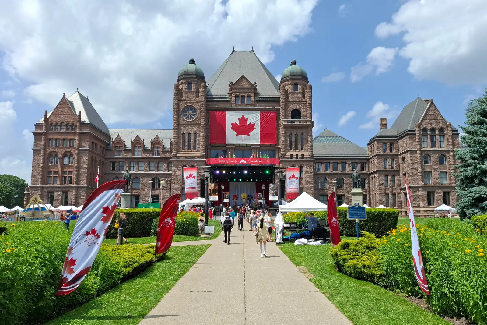 Canada Day at Queen’s Park in Toronto, with a large flag on the Ontario Legislative Building and banners along the path
