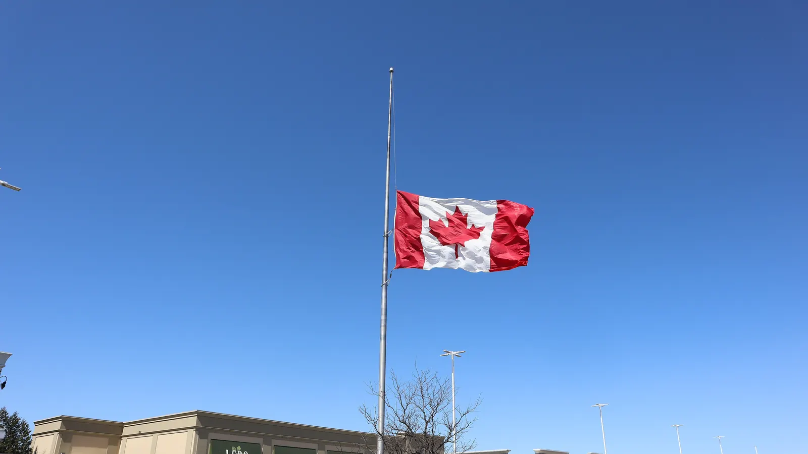 The flag of Canada at half-mast on a tall flagpole in Bolton, Ontario, in 2025