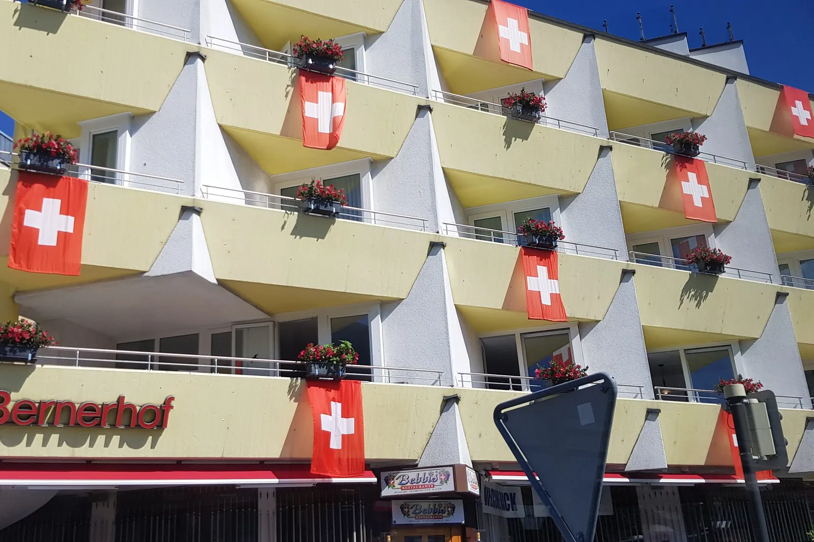 Hotel in Interlaken mit Schweizerfahnen an allen Balkonen