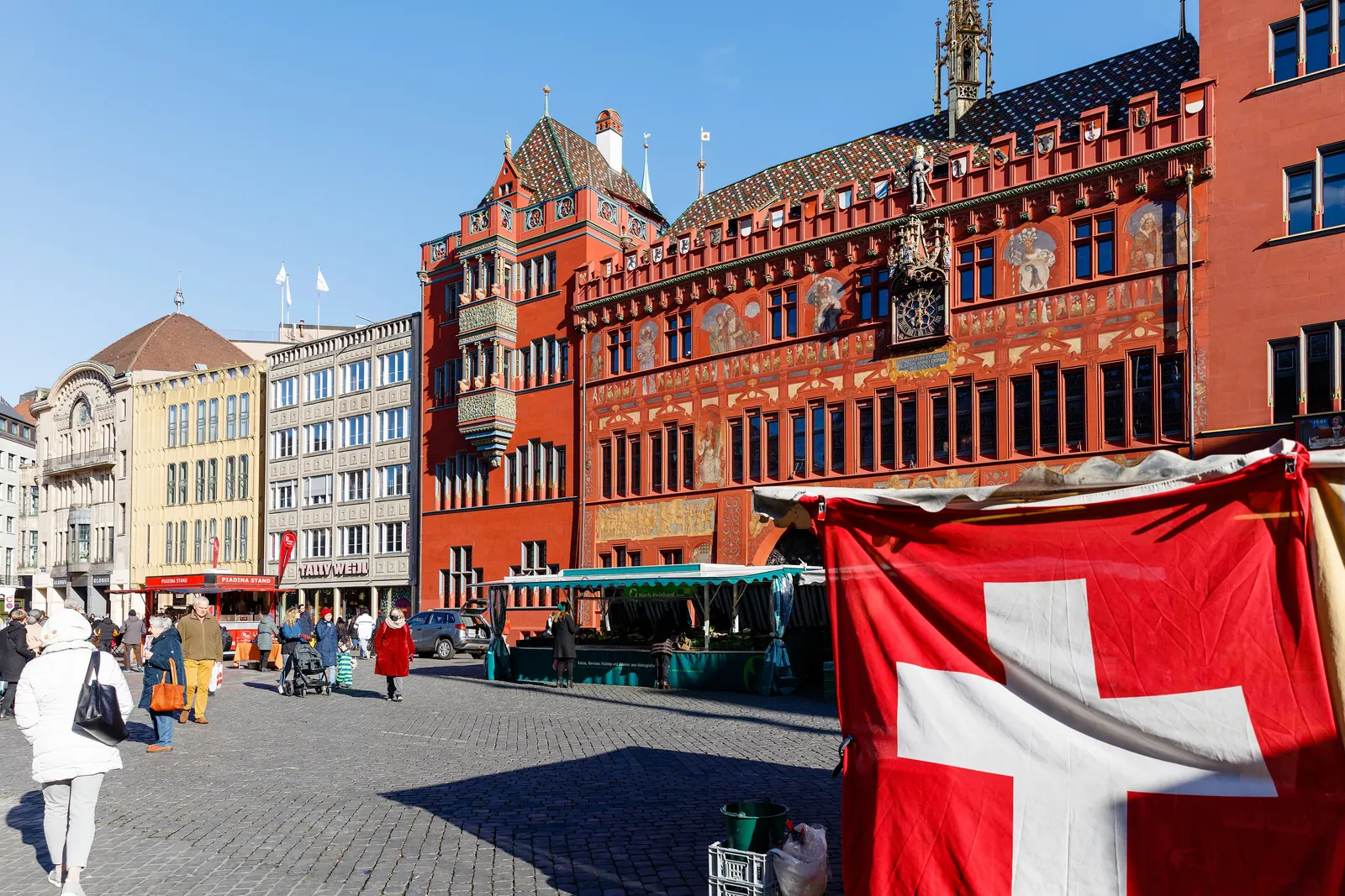 Grosse Schweizerfahne vor dem roten Rathaus am Marktplatz in Basel