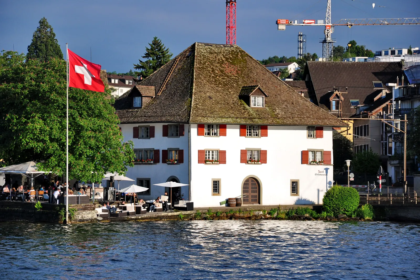Fahnenmast mit Schweizerfahne am Seeufer vor der alten Sust in Horgen am Zürichsee