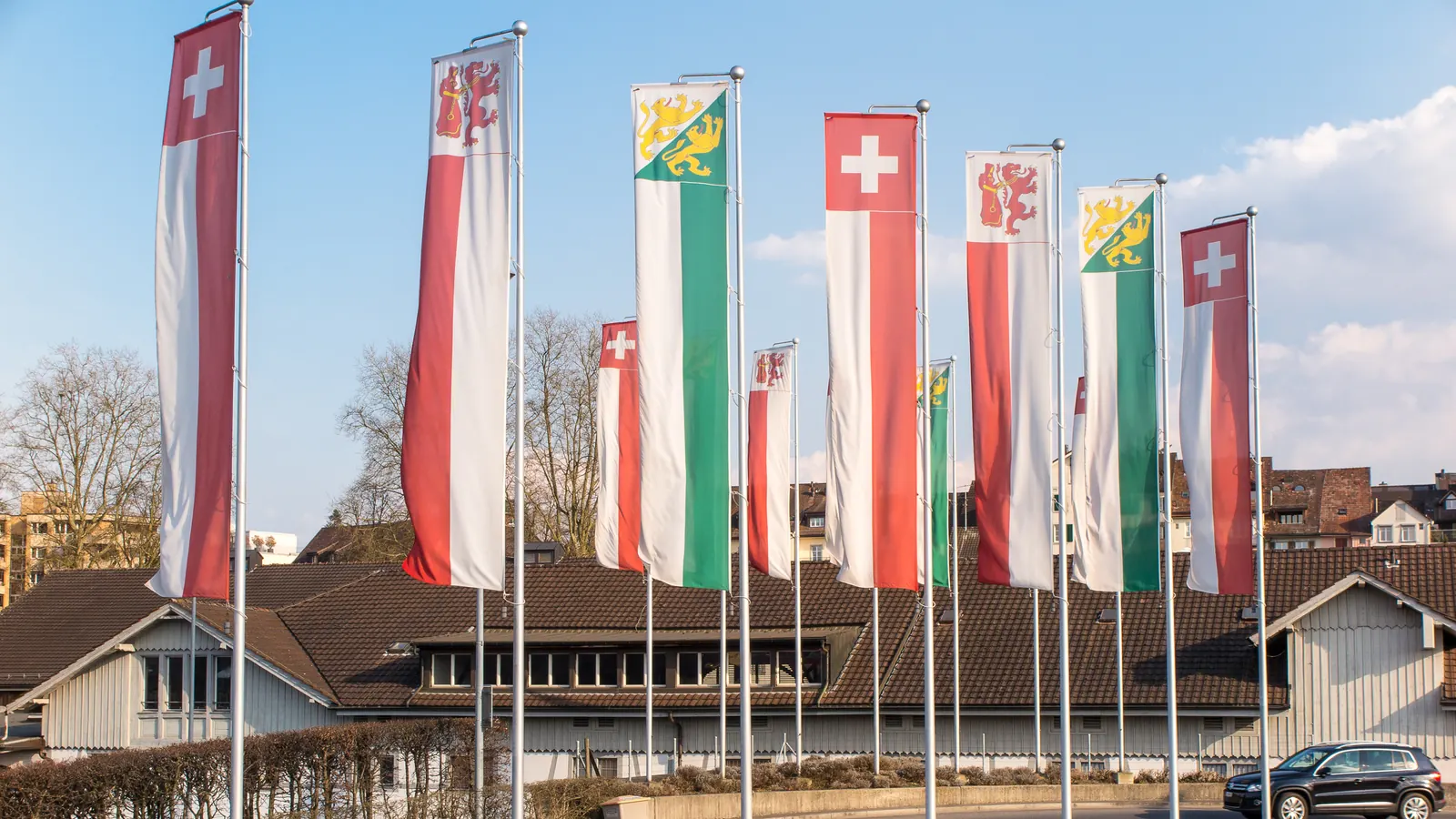 Lange Reihe von Fahnenmasten am Bahnhof Frauenfeld, an denen sich Schweizerfahne, Stadtfahne und Thurgauer Fahne wiederholen