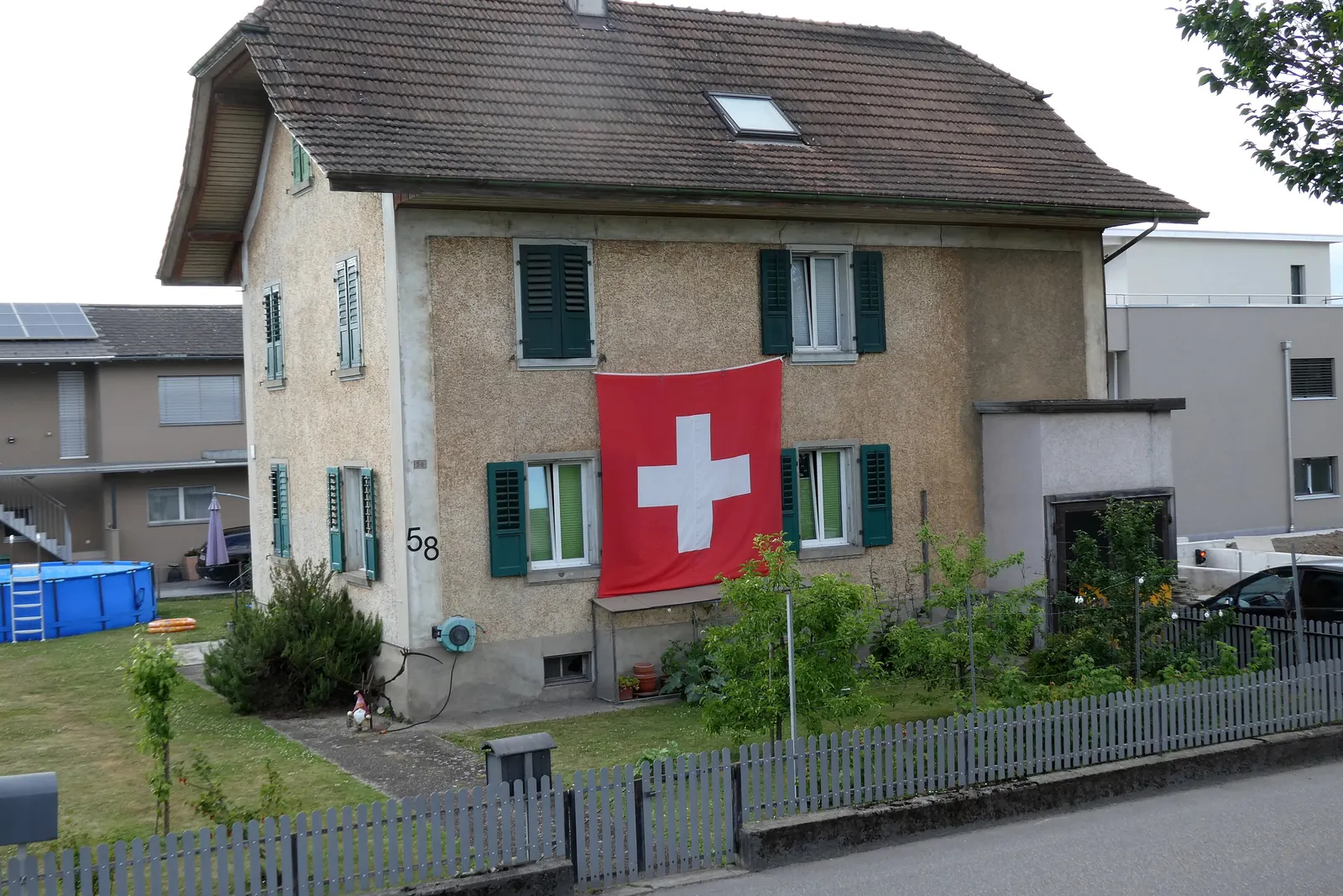 Grosse Schweizerfahne an der Fassade eines Wohnhauses in Biberist
