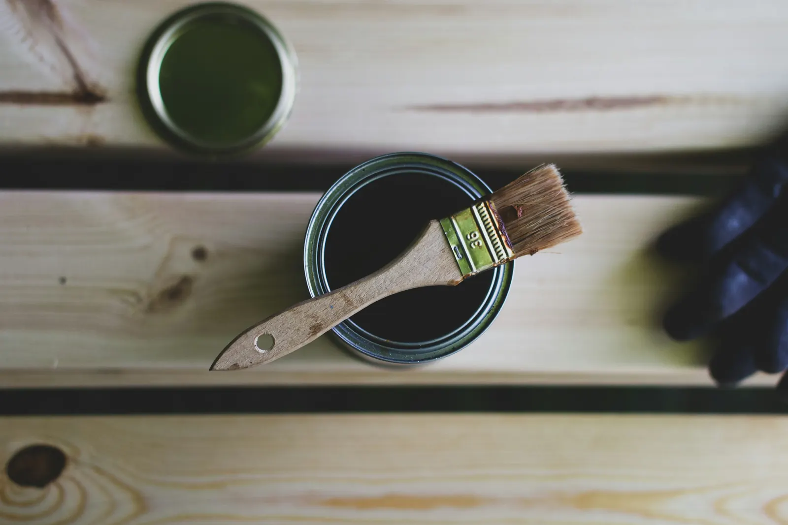 A tin of paint and a brush