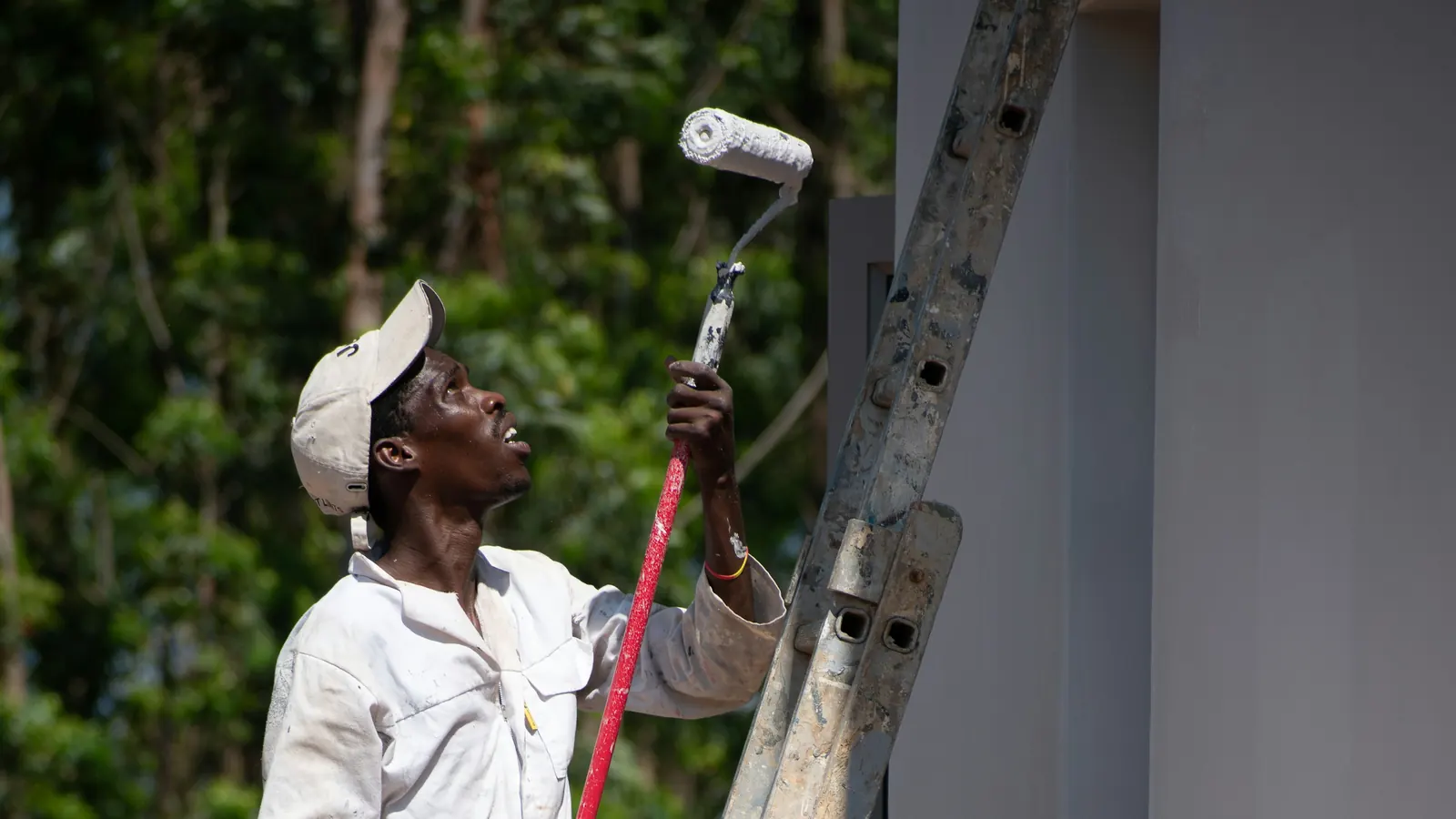 A painter with a roller on a ladder