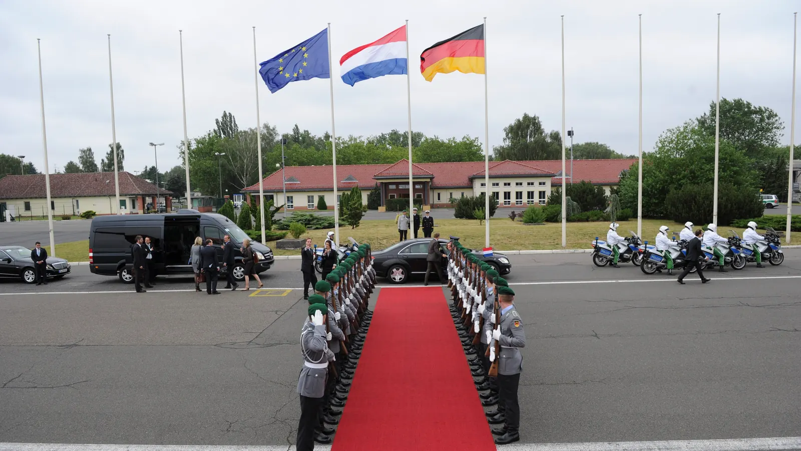 Europaflagge, niederländische Flagge und Bundesflagge an Masten beim Empfang mit militärischen Ehren am Flughafen Tegel in Berlin