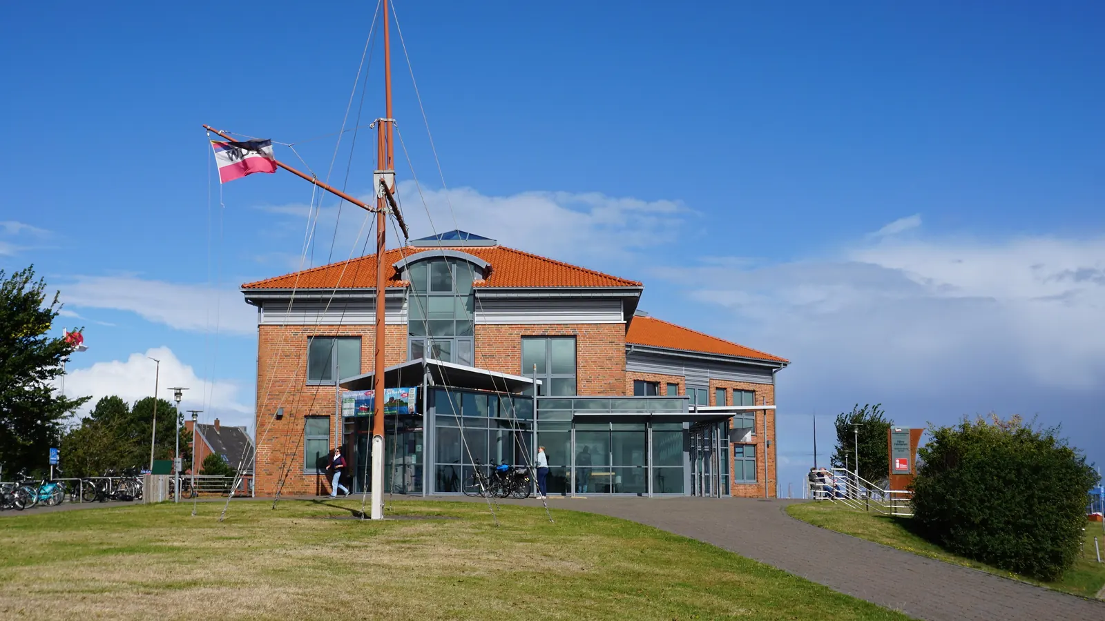 Backsteinbau der Reederei in Wyk auf Föhr mit einem hohen Fahnenmast mit Rah davor