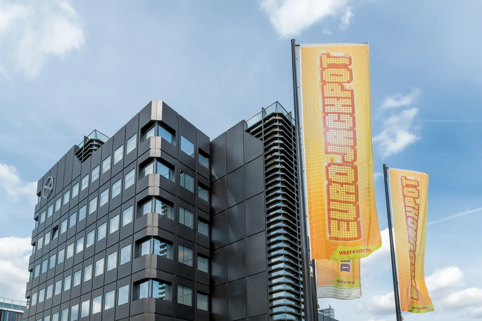 Bürohaus in Münster mit gelben Werbefahnen an zwei Masten