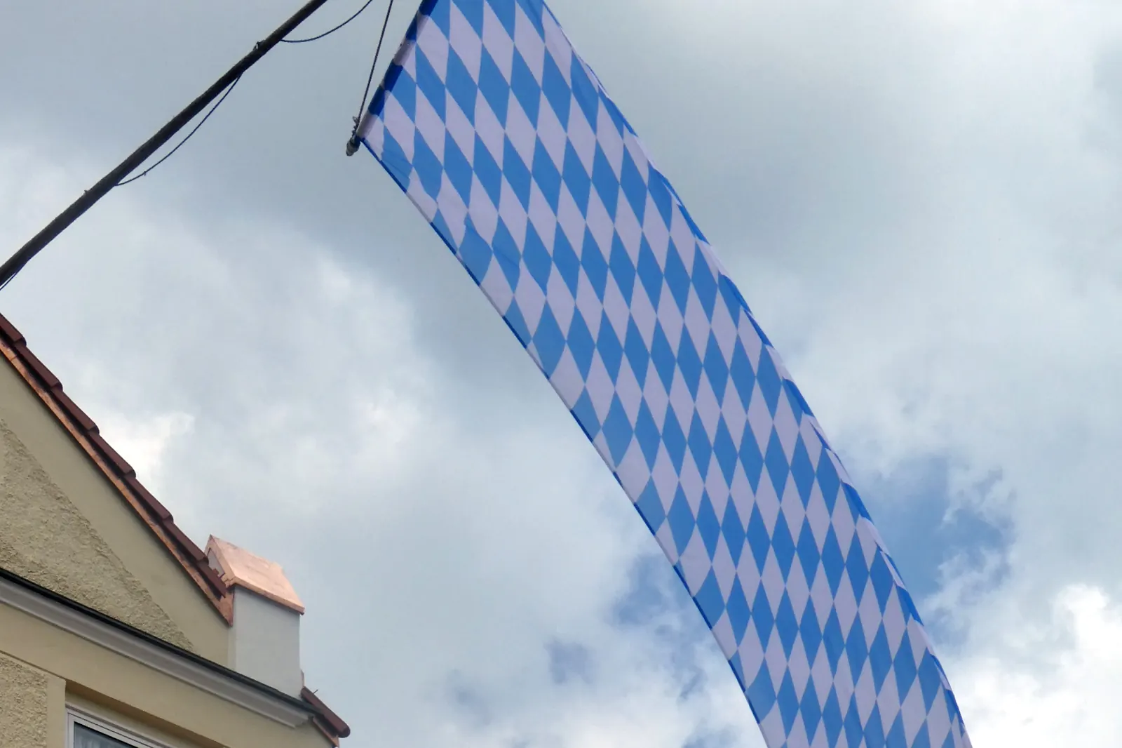 Bayerische Rautenflagge in Weiß und Blau an einem Ausleger an einem Haus in Bad Tölz