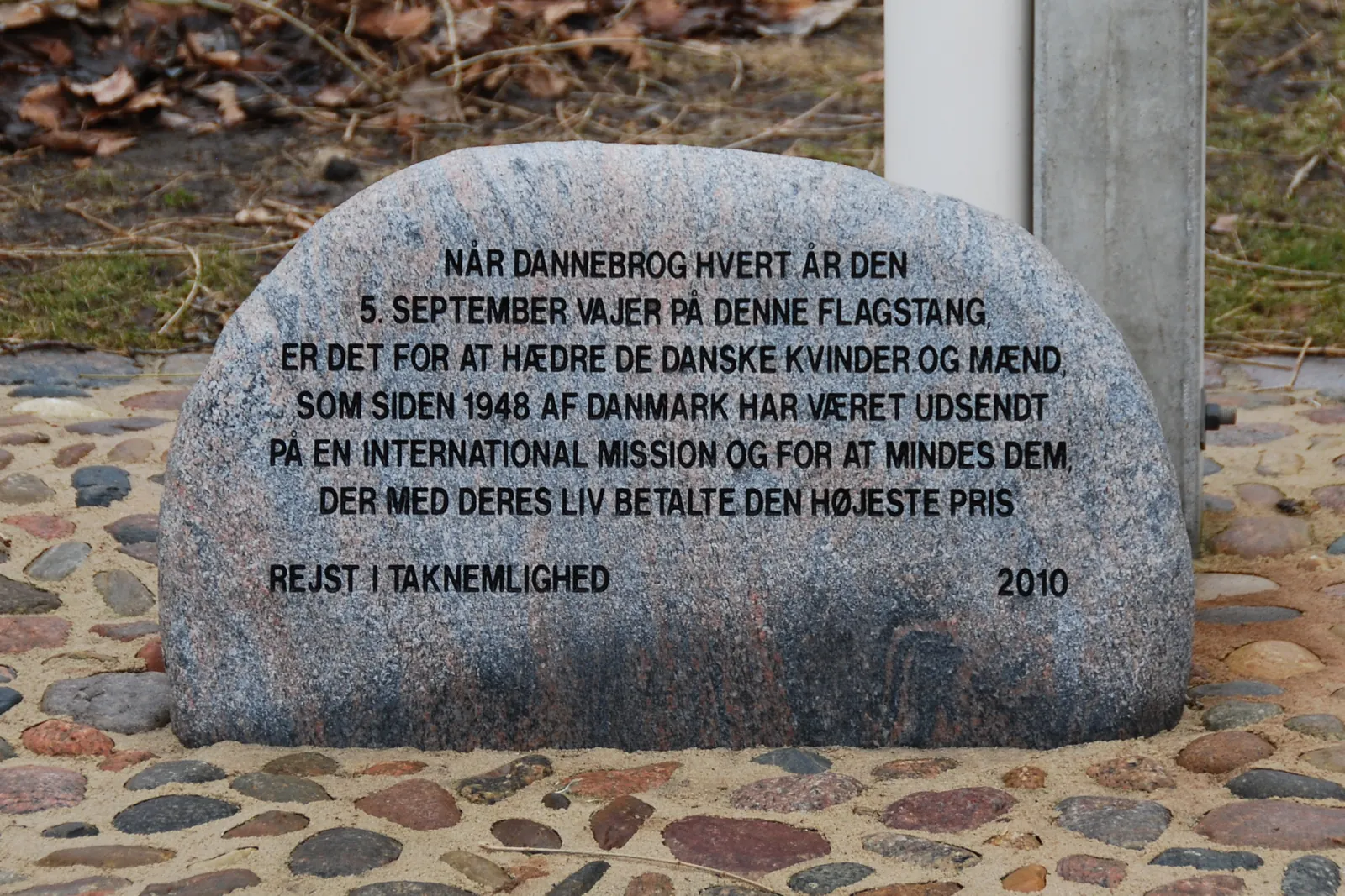 Mindesten med indskrift om flagdagen 5. september ved foden af en flagstang
