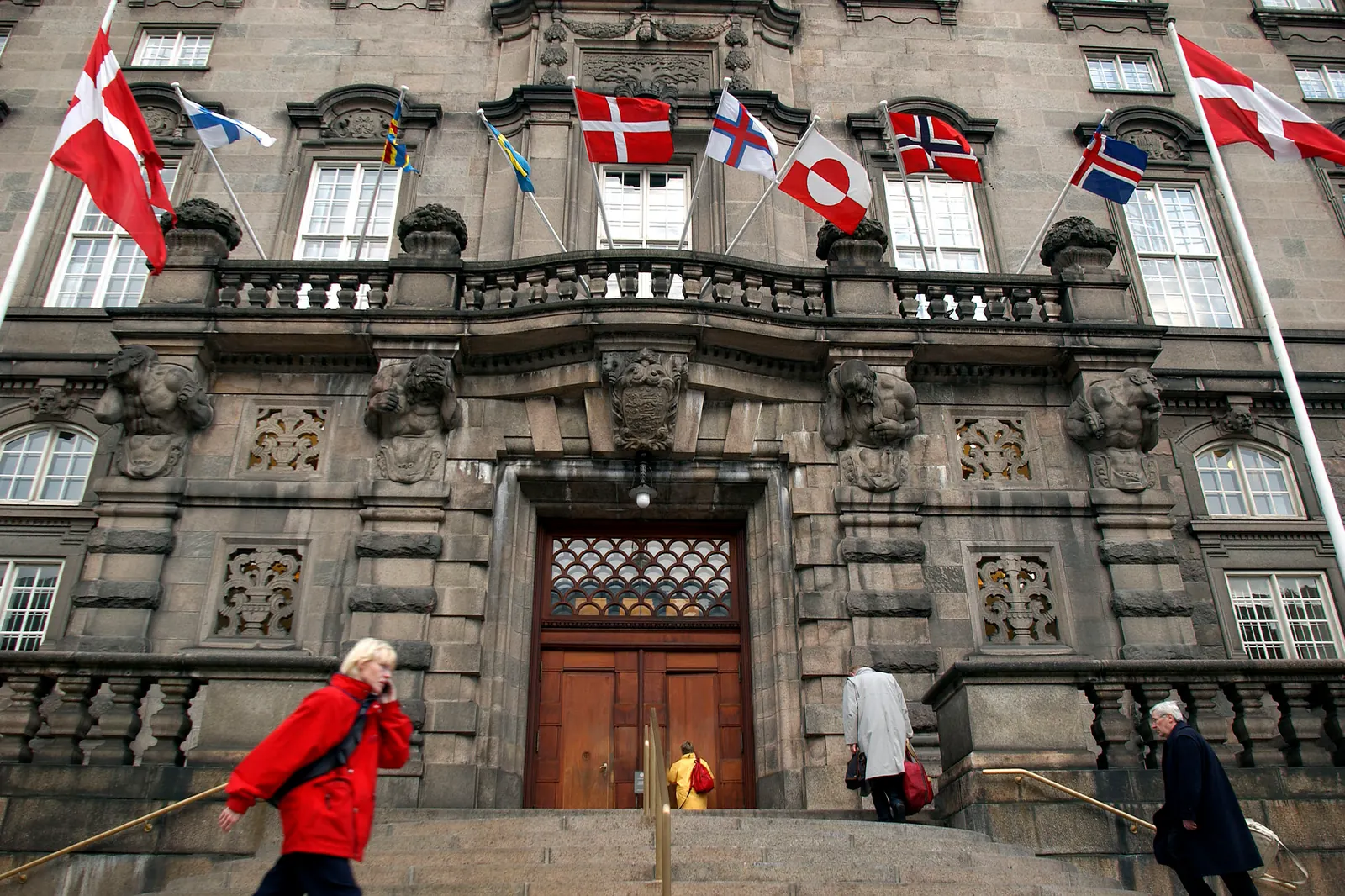 Dannebrog og de andre nordiske flag på flagstænger på facaden af Christiansborg
