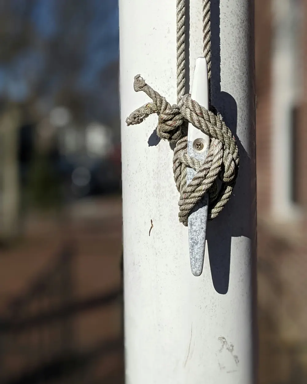 Flagsnor viklet om en klampe på en hvid flagstang