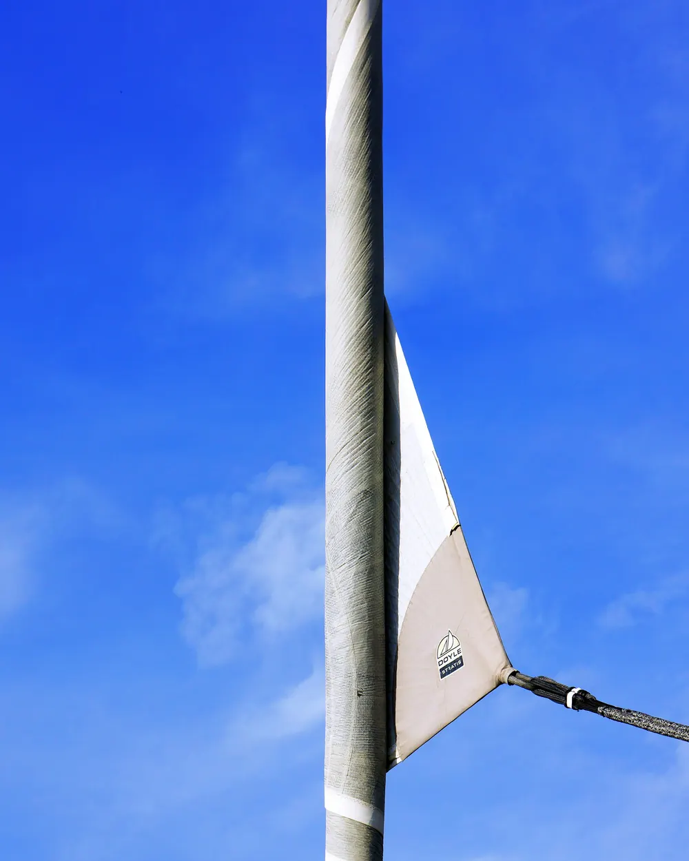 Flagsnor og et hvidt flag ved en flagstang mod blå himmel