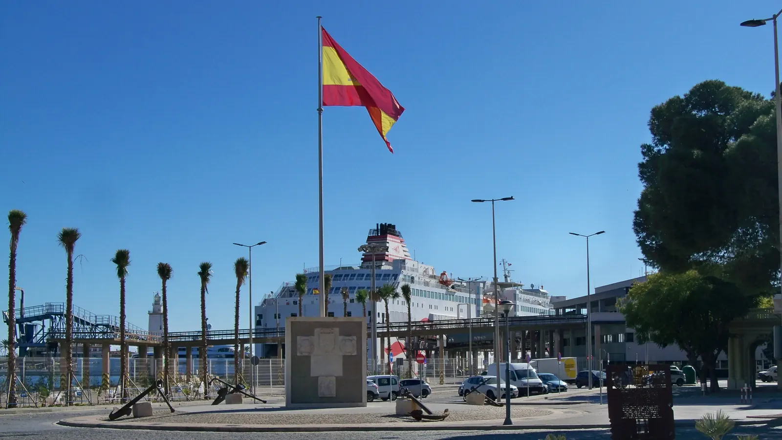 Un alto mástil con la bandera de España en el puerto de Málaga