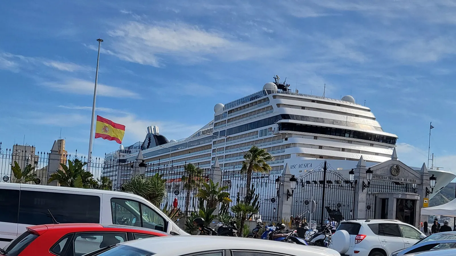 La bandera de España a media asta en el puerto de Ceuta tras la muerte del papa Francisco, con un crucero al fondo