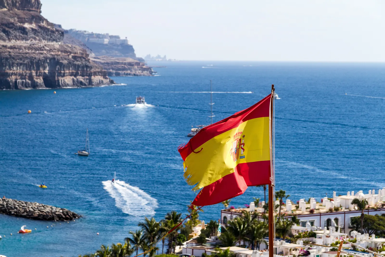 La bandera de España ondea sobre el mar en Puerto de Mogán, en Gran Canaria