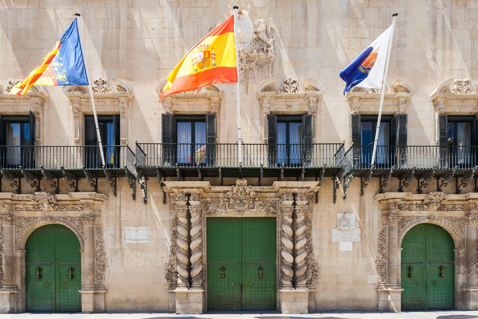 Fachada del Ayuntamiento de Alicante con la bandera de España en el centro y las de Alicante y la Comunidad Valenciana a los lados