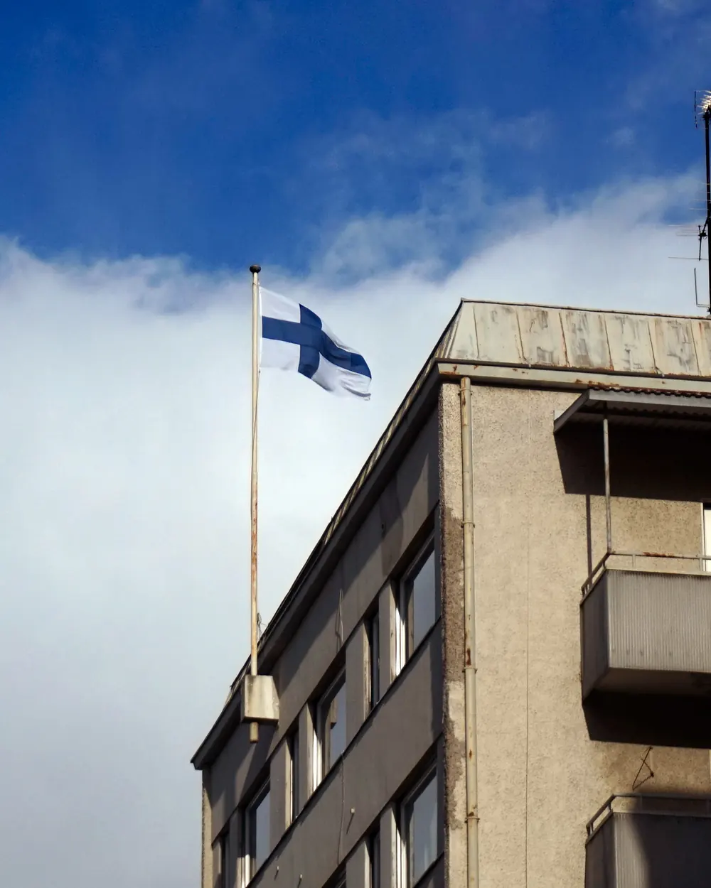 Lippusalko ja Suomen lippu kerrostalon katolla