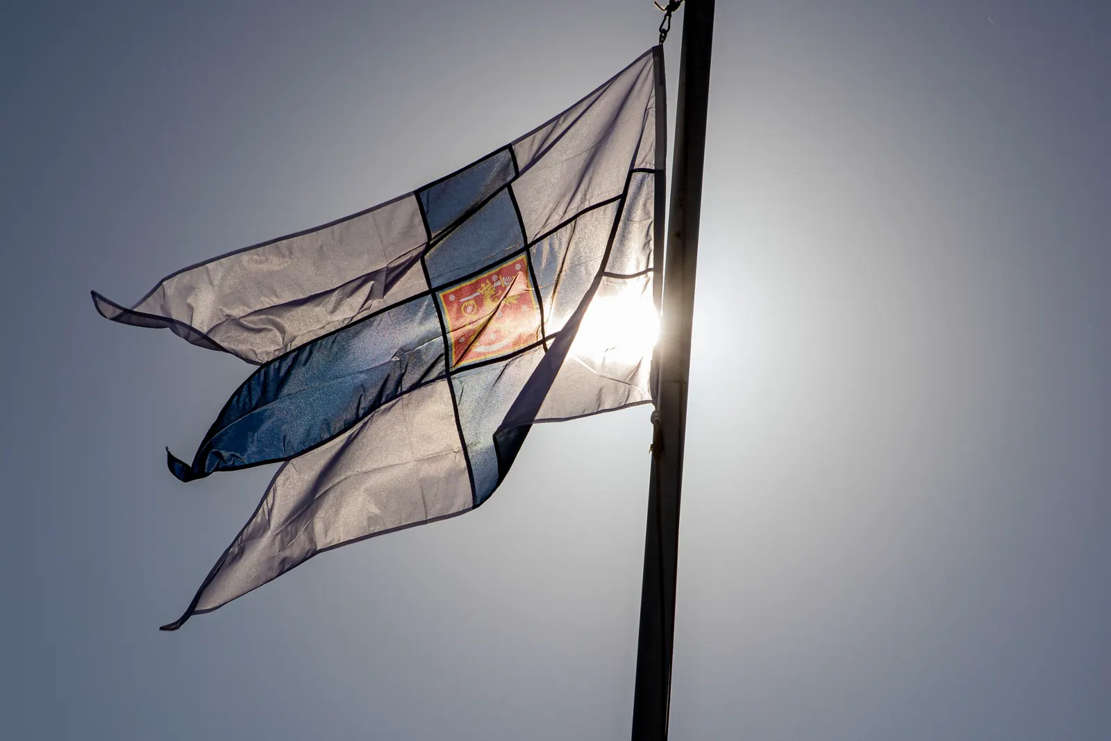Rispaantunut ja haalistunut valtiolippu salossa vastavalossa