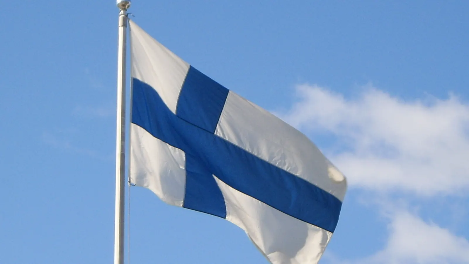 Siniristilippu liehuu valkoisessa salossa sinistä taivasta vasten