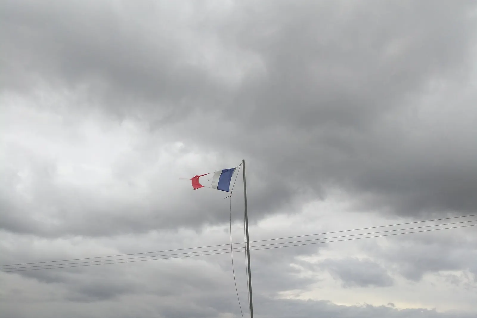 Le drapeau français en haut d’un mât au bord d’un champ, près de la caserne des sapeurs-pompiers de Thervay