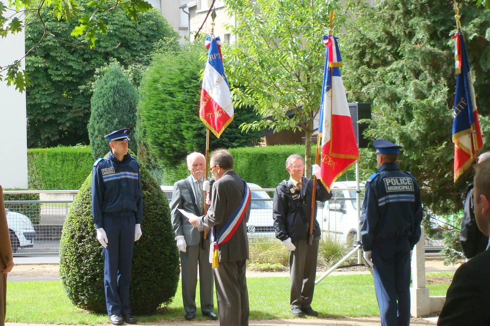 Cérémonie du 14 juillet avec des porte-drapeaux, des policiers municipaux et un élu ceint de l’écharpe tricolore