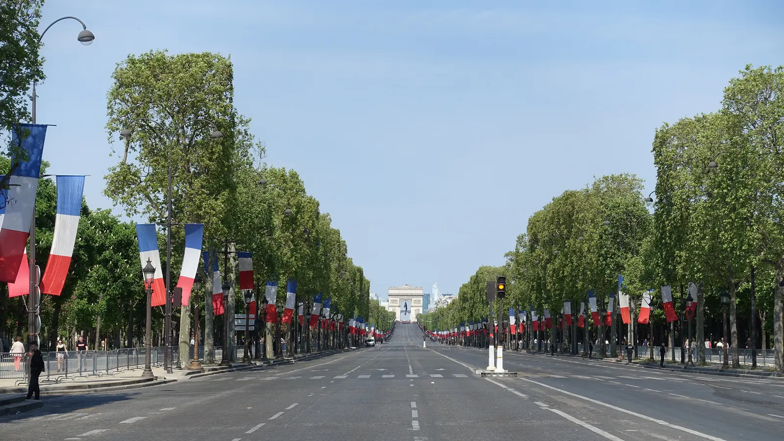 L’avenue des Champs-Élysées pavoisée de drapeaux tricolores jusqu’à l’Arc de Triomphe