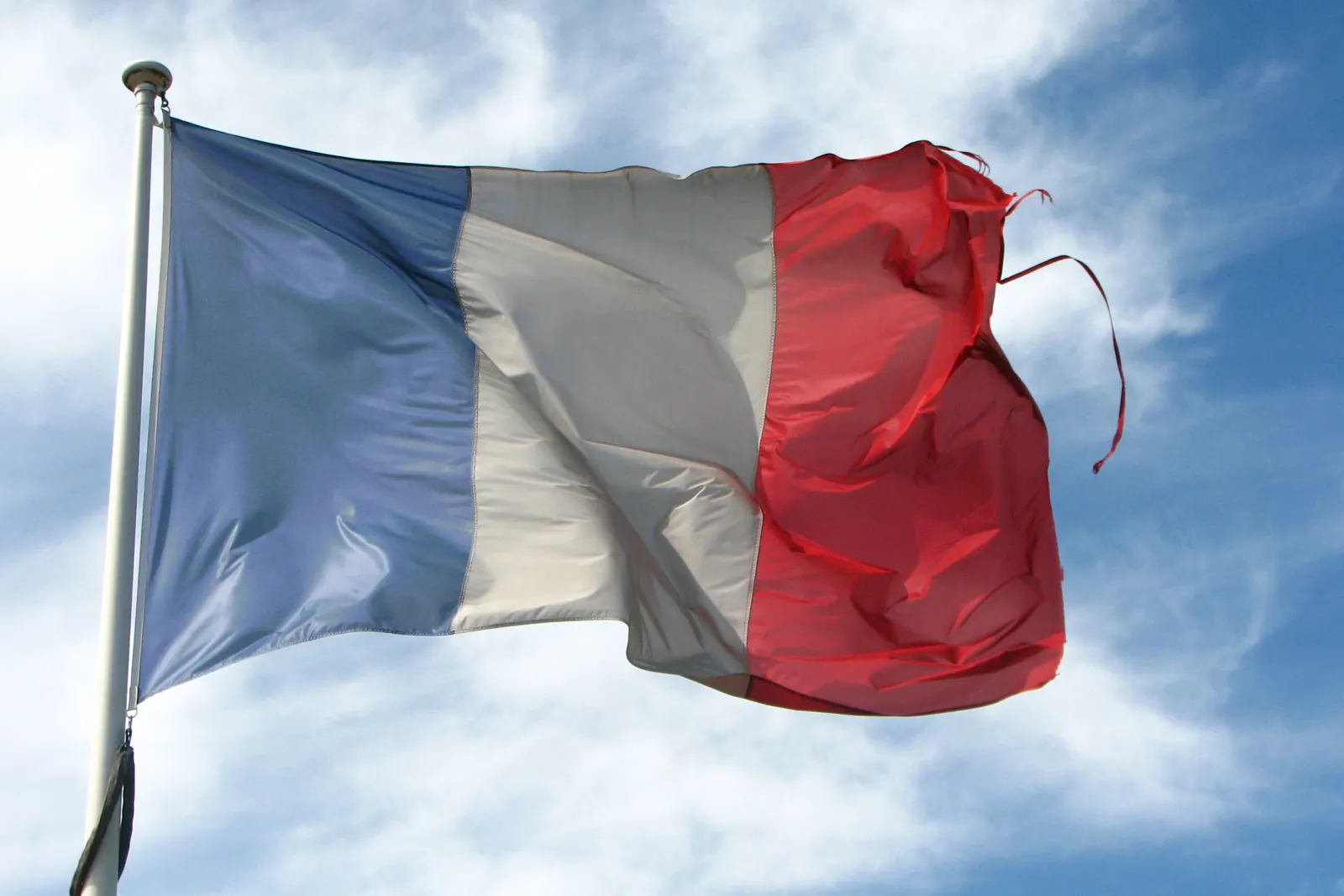 Un drapeau tricolore usé et effiloché au bout du rouge